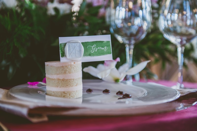 Individual Cake on raspberry place setting and green name card surrounded by tropical flowers Allison Shelrud Cakes Vancouver Island