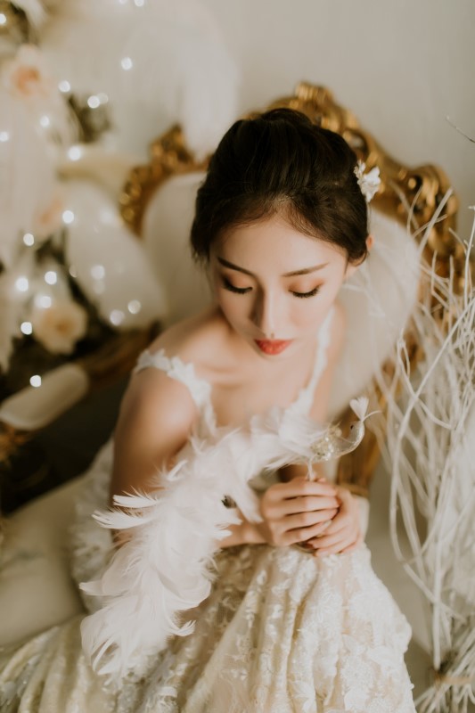 Dreamy White Wedding bride in lace gown with straps holding feathers