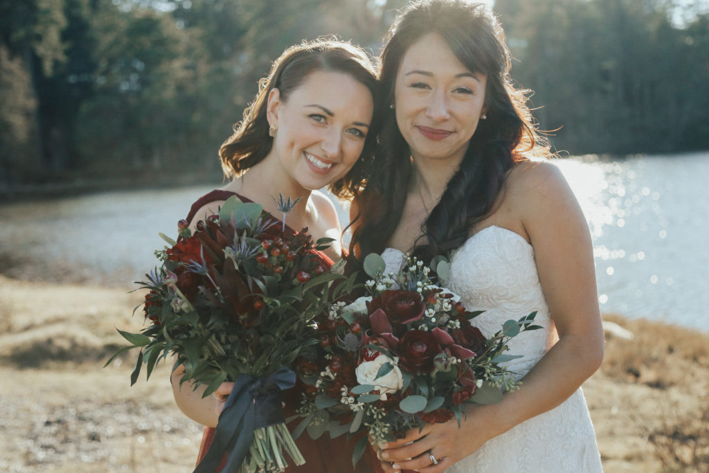 West Coast Weddings Magazine bride and bridesmaid holding up their bouquets from West Coast Weddings Magazine