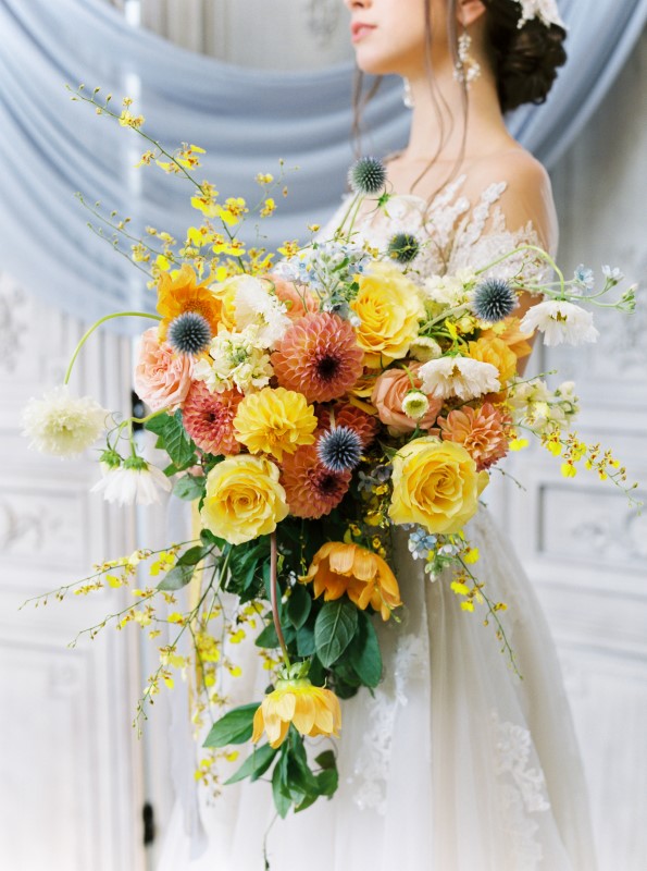 Cascading Bridal Bouquet with yellow roses and orange and blue flowers by Arizel Flowers Vancouver