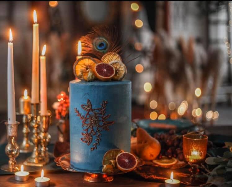 Blue Cake with Gilt Embossing and burnt orange flowers surrounded by candles Cobble Hill Cake Co