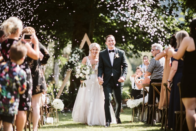 Newlyweds and Confetti after ceremony by Erin Wallis Photography