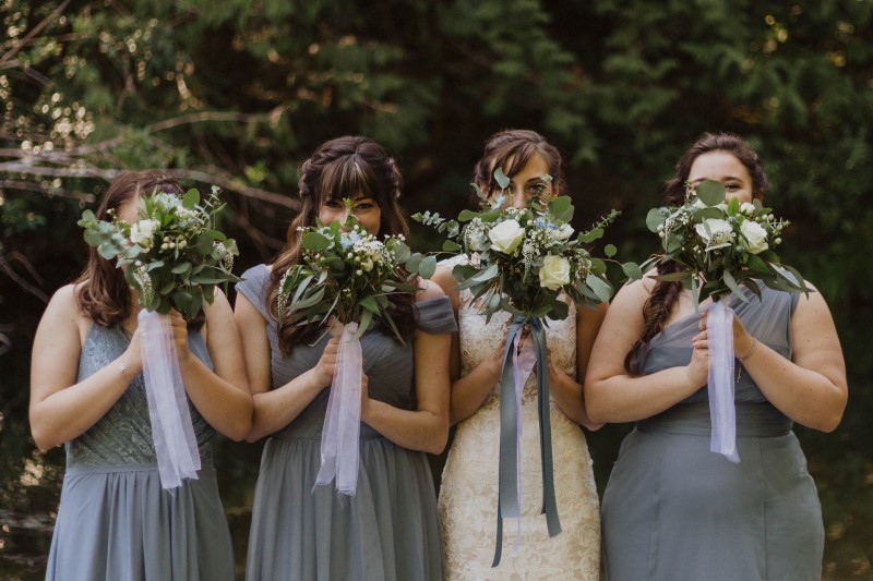 Bridal Party Holds Up Florals by Lucinda Larsen Events