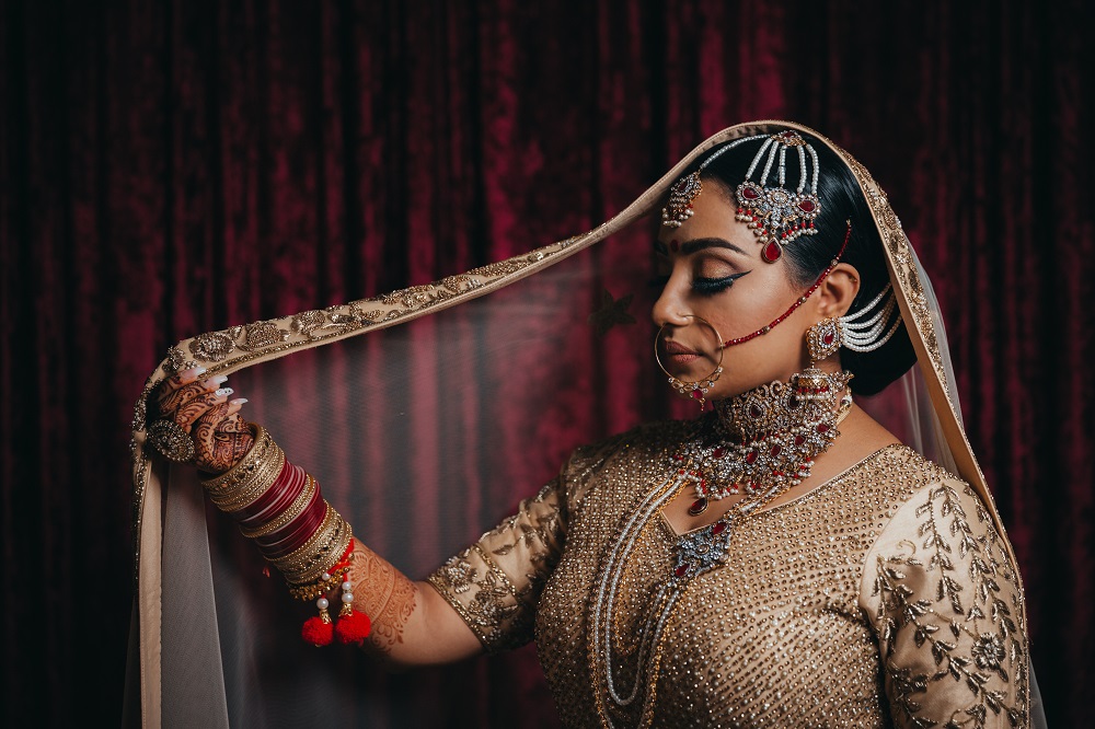 Indian Bride in blush and burgandy saree and veil by Dreamfinity Studios