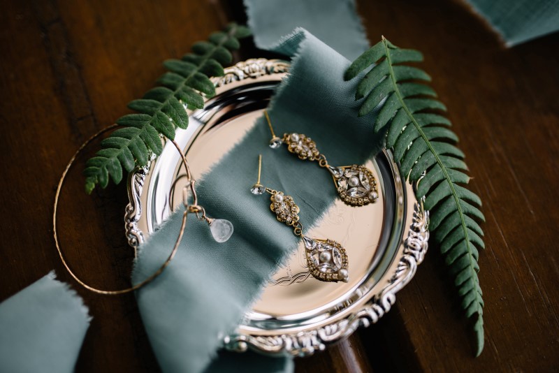 Seaside Romance Wedding Jewelery sitting in silver platter on smoky blue ribbon