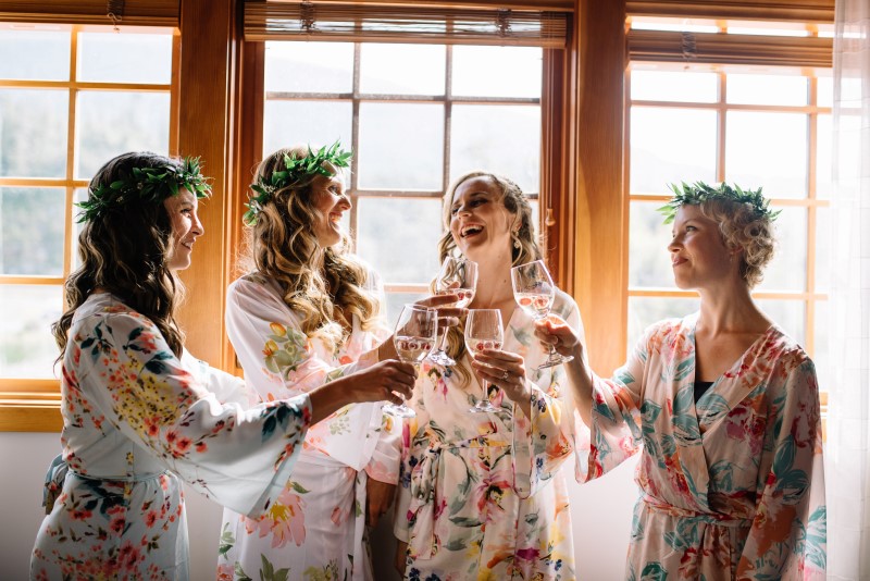 Seaside Romance Wedding Bridal Party champagne toasts while in floral robes at Telegraph Cove