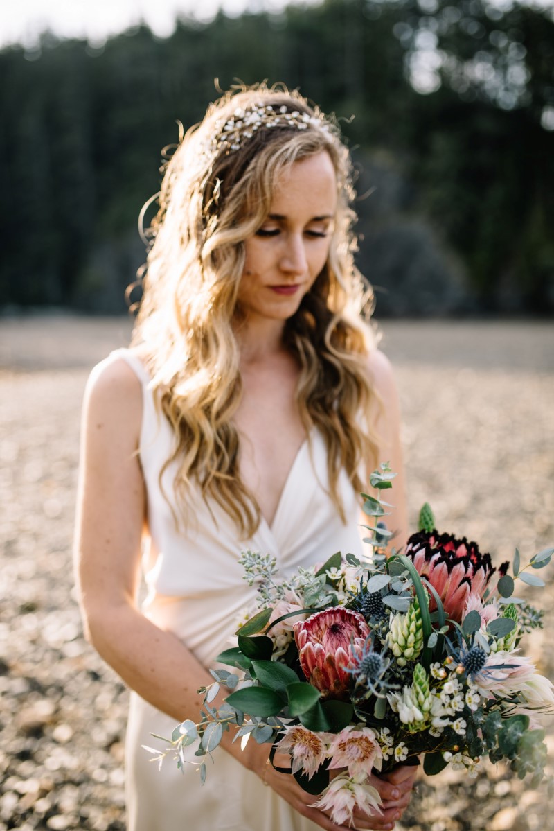 Sun Shines on Bride Holding Thrifty Foods Bouquet at Telegraph Cove