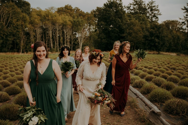 Bride and bridemaids walk through lavender field with hair by Brooklynn Seefried of Head Case Hair Studio on Vancouver Island