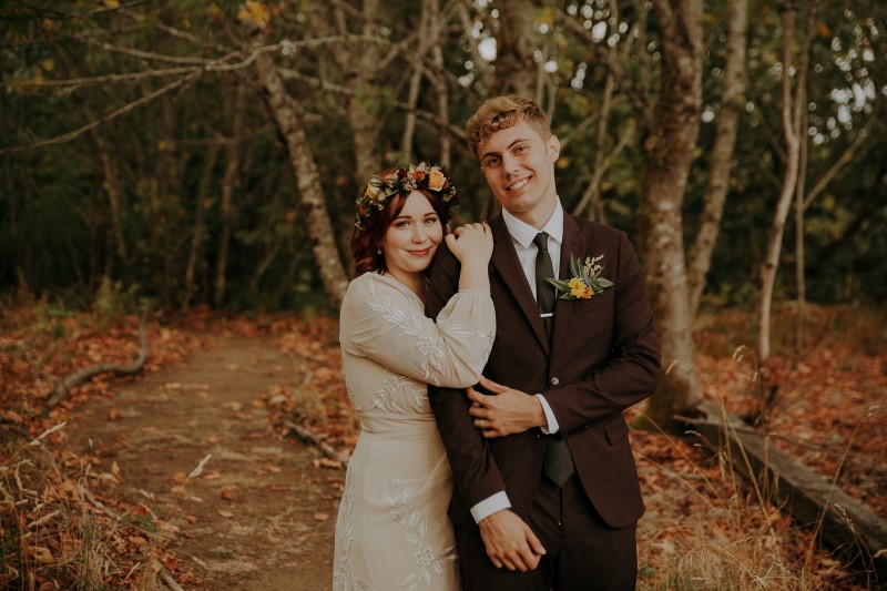 Newlyweds lean on each other in the forest by LumiPhoto