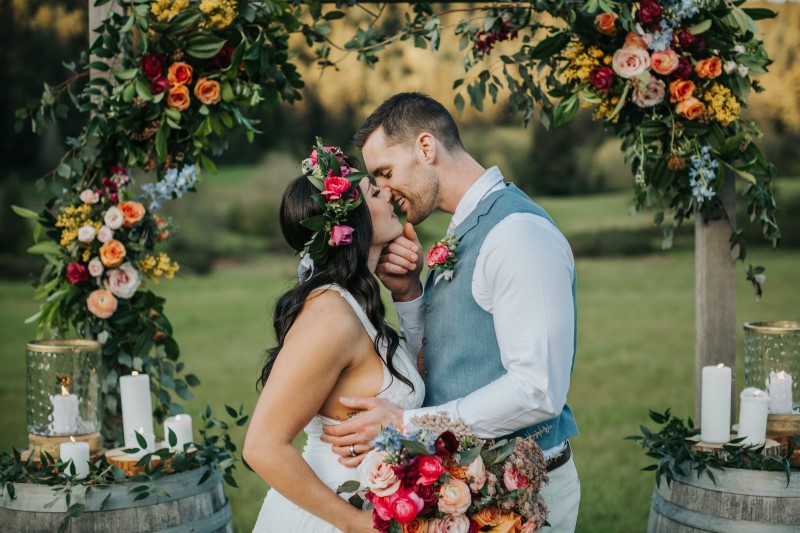 Newlyweds kiss at outdoor dance with cafe lights 