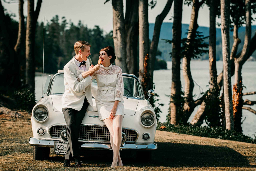 Twiggy Eyes + The Beehive retro couple eat popsicles against vintage car along the ocean