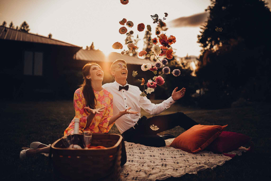 60's Retro Wedding Couple throw flowers in the air at outdoor picnic in Cobble Hill