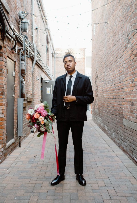 Groom Holding Bouquet by En Vied Events in Victoria