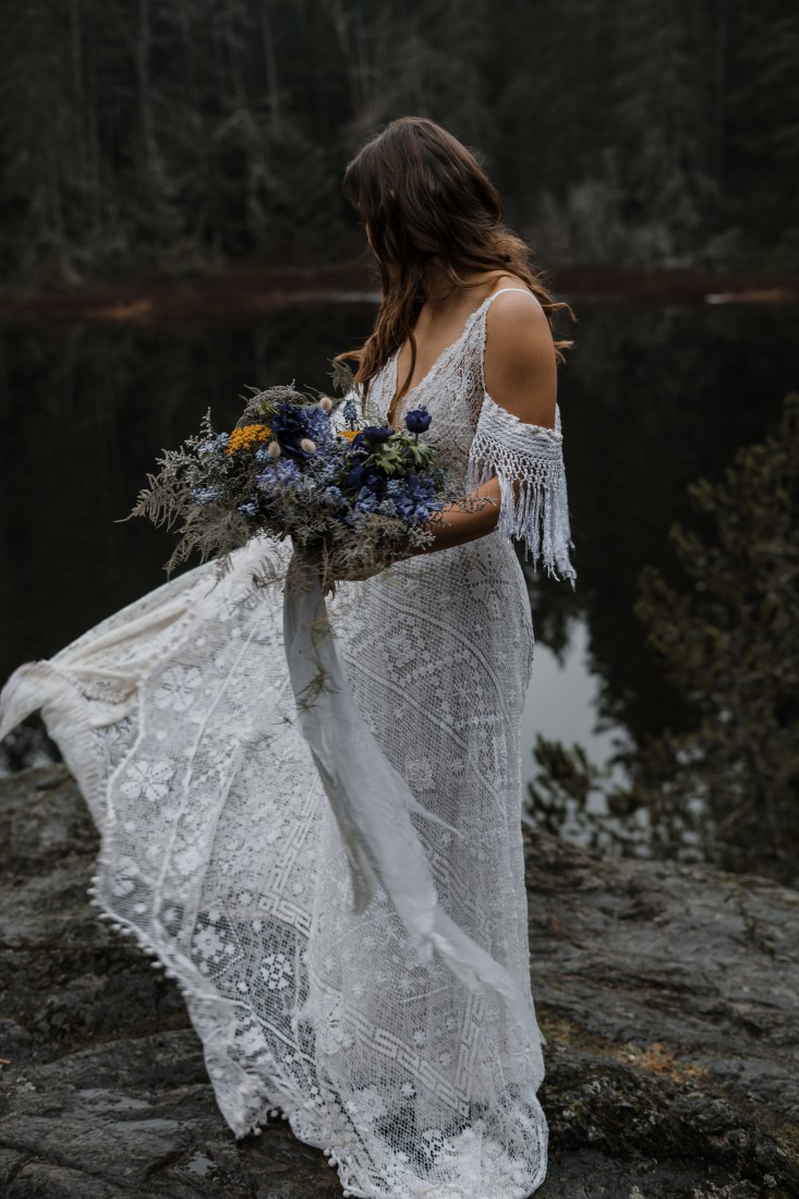 Bride in lace reclaimed gown with off the shoulder ruffle and bouquet 