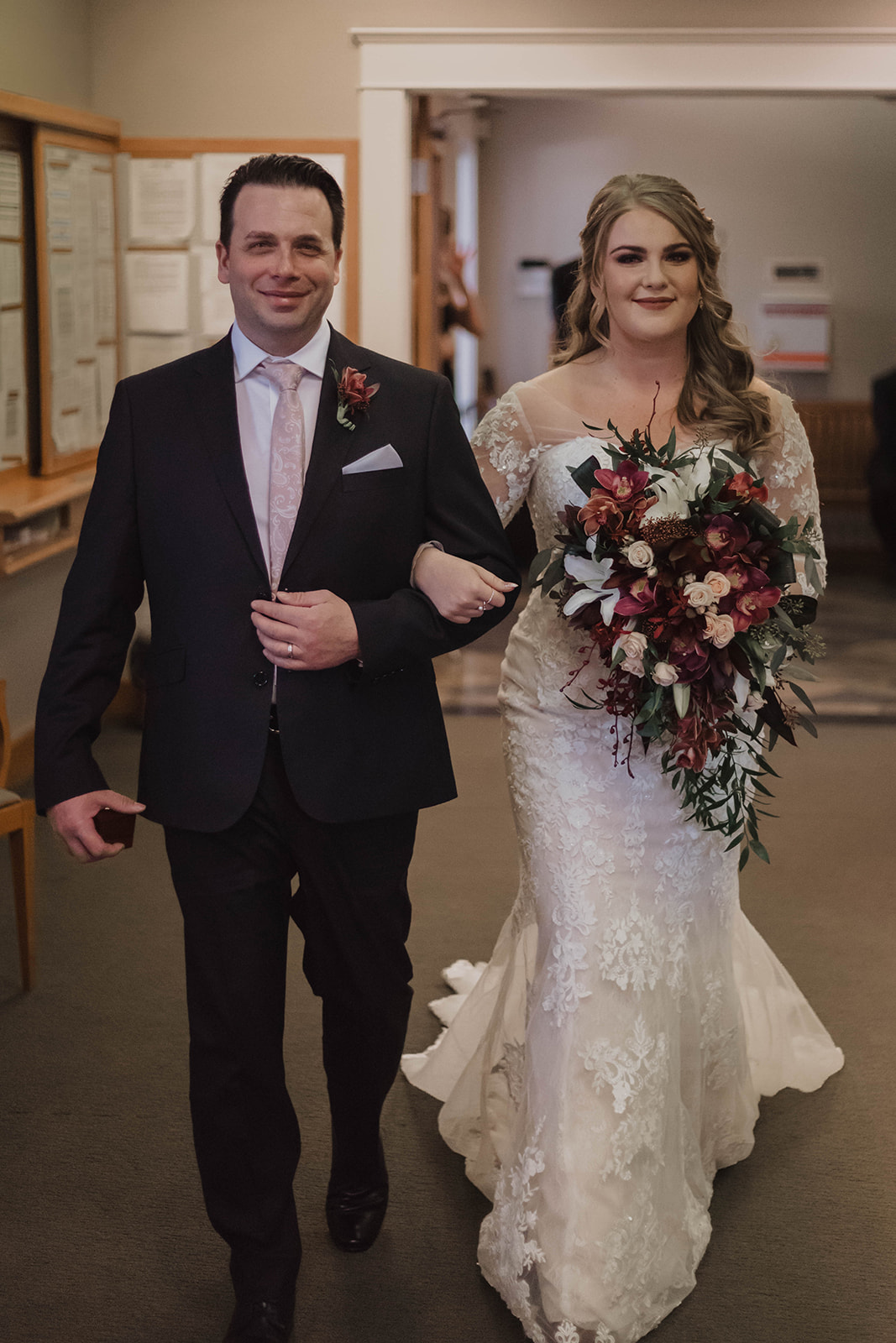 Father walks bride in form fitting lace gown