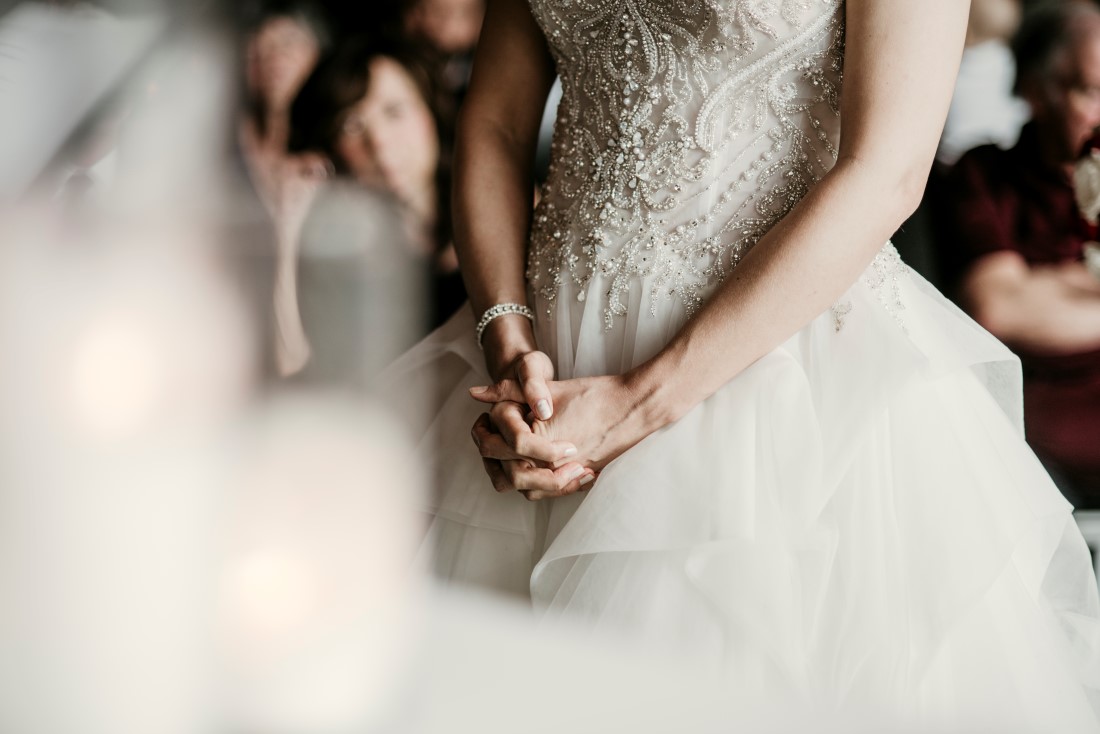 Bride holds her hands together in front of her dress during Black Rock ceremony 