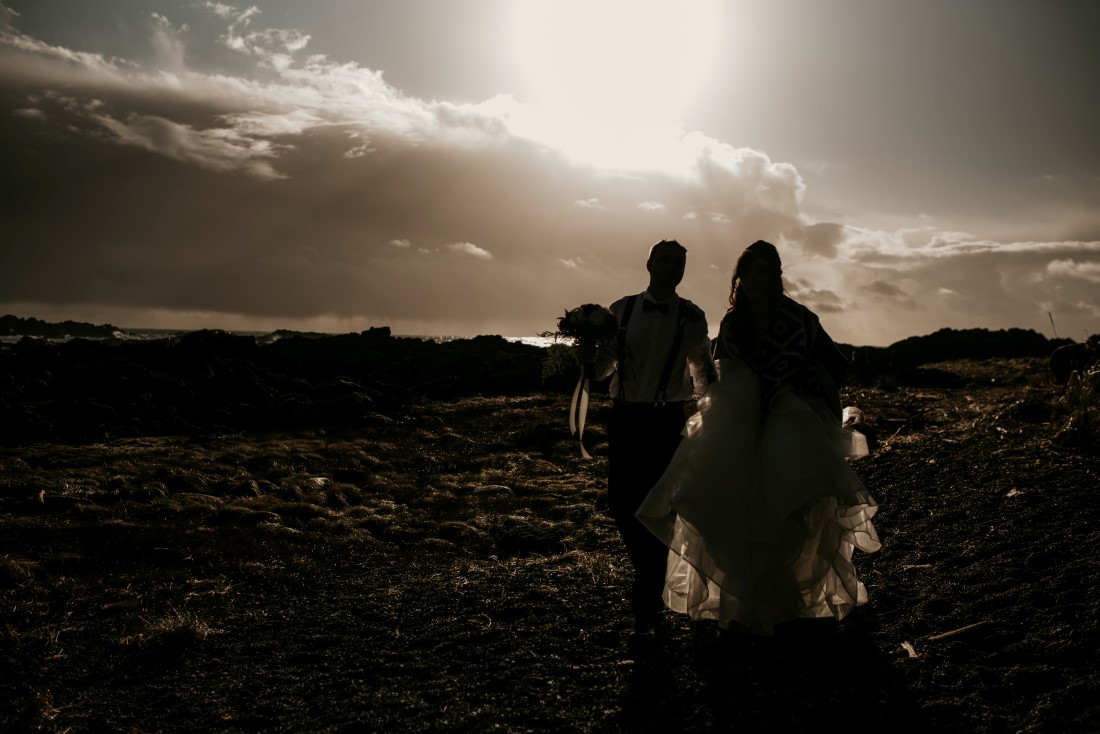 Newlyweds walk along the ocean during sunset by Jen McLeod Photography