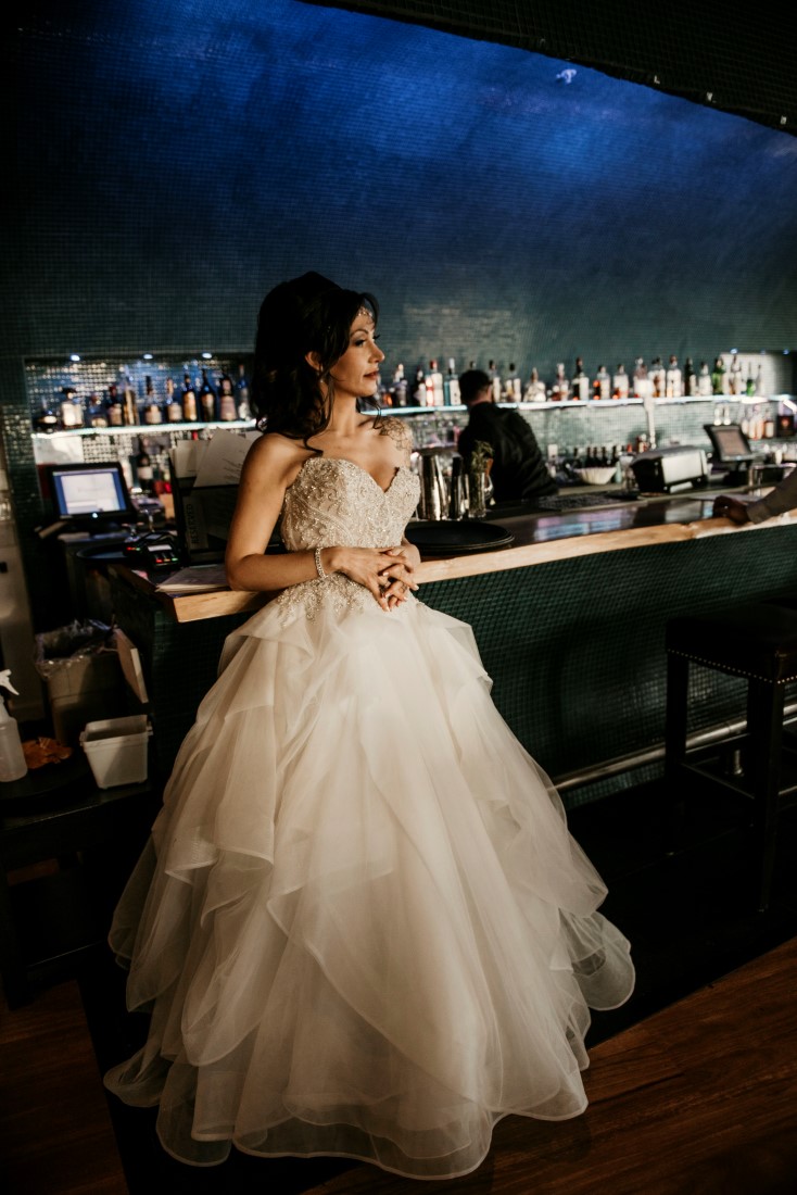 Bride leans against blue tile Big Beach Bar and Lounge at Black Rock Oceanfront Resort Vancouver Island