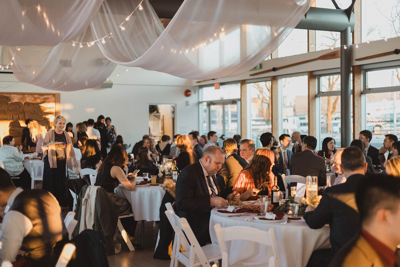 UBC Boathouse Wedding Reception guest sit below white fabric ceiling treatment by Proline International Trading Vancouver