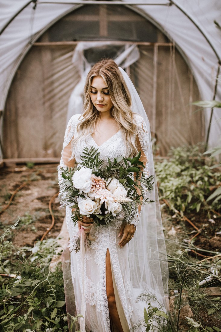 Bride holds bouquet of white flowers and greenery wearing Willowby and Watters by Shades of White