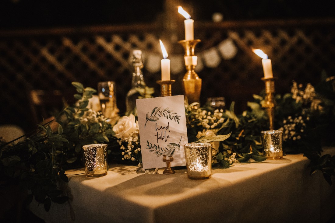 Tapered candles, greenery and sign on wedding guest table by Flourish Events Vancouver