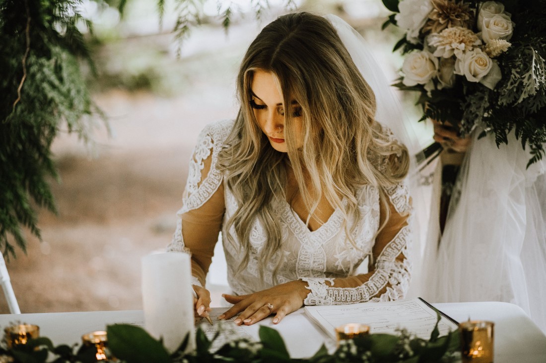 Bride signs register at farm wedding by Wild Oak Collective Vancouver Island