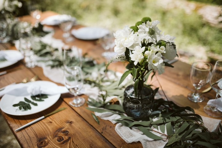 Wood Reception table with greenery and white fabric in the woods