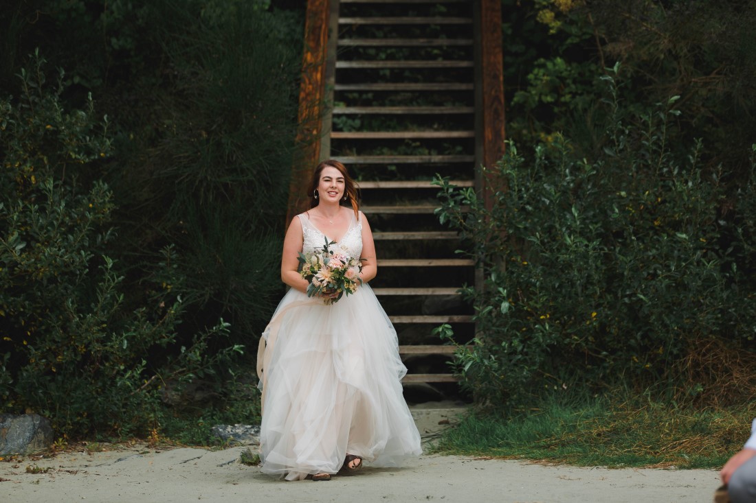 Bride walks towards her wedding ceremony on Tofino beach