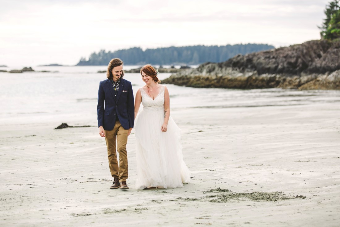 Ocean Wedding Couple walk along beach together in Tofino