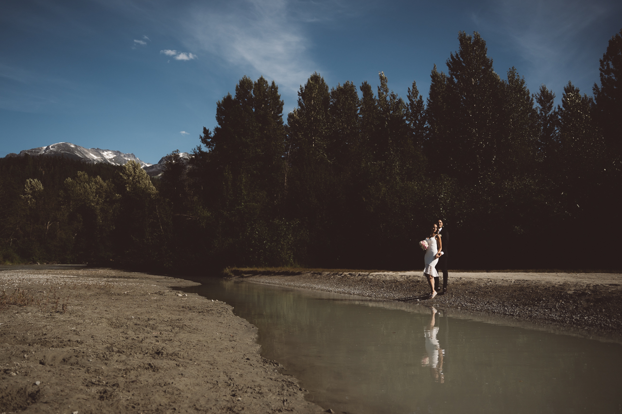 Bride and groom by Whistler river 