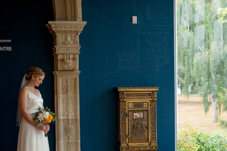 Bride holds her bouquet in front of Art Museum of Vancouver