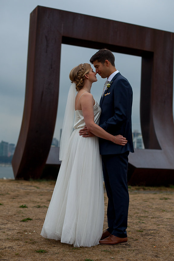 Newlyweds on the beach in front of art installation in Vancouver