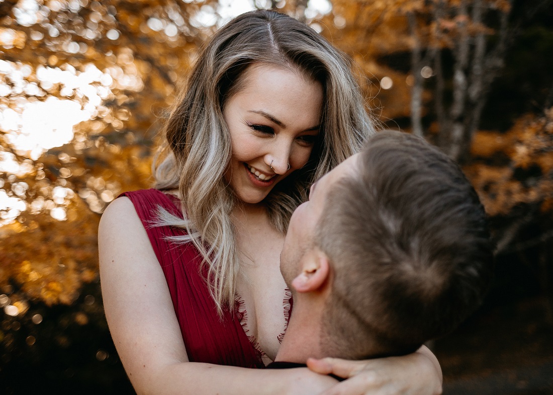 Newly Engaged Bride to Be in burgundy dress smiles at fiancée