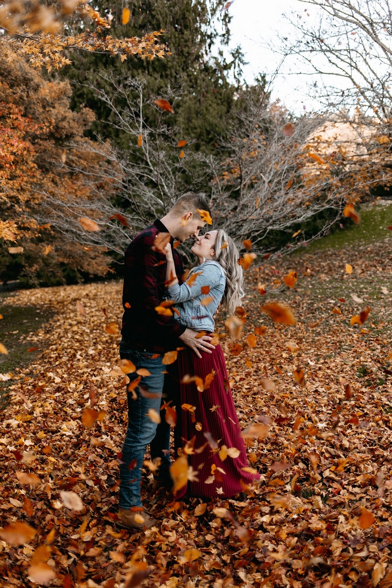 Couple embrace surrounded by autumn leaves on Vancouver Island