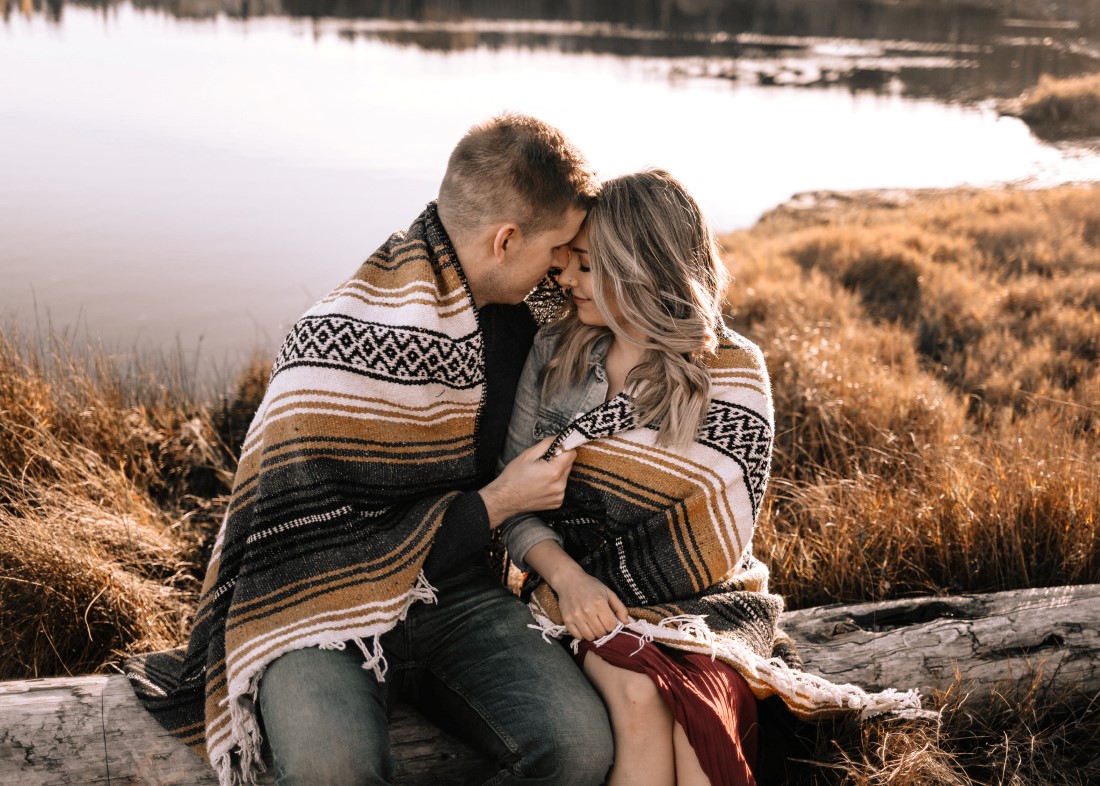 Autumn Engagement Couple cuddle under blanket near ocean on Vancouver Island