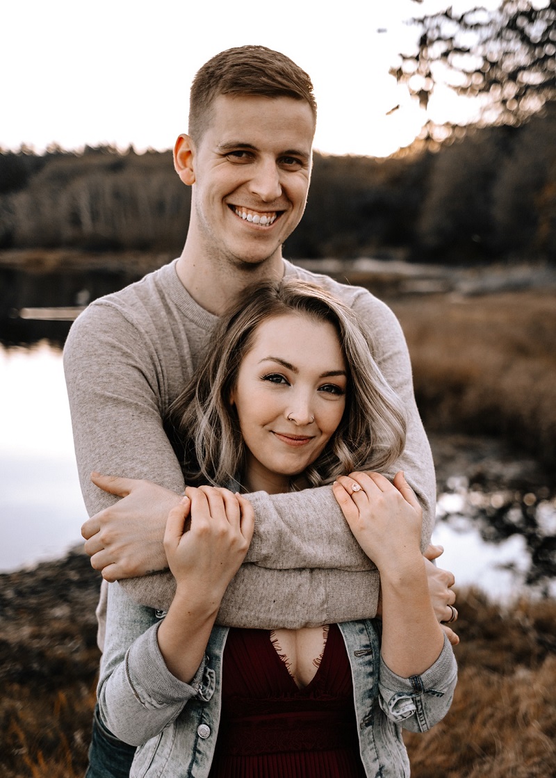 Smiling engaged couple on waters edge at Hatley Castle Victoria