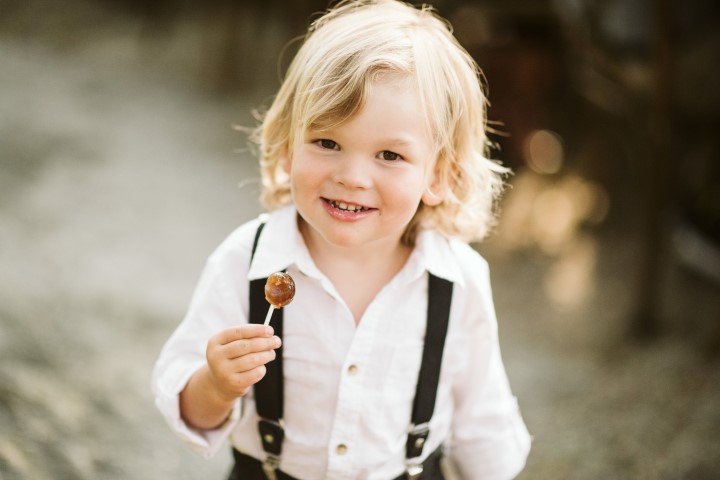 Little boy eats cake pop with a smile by Truffles Catering Vancouver Island