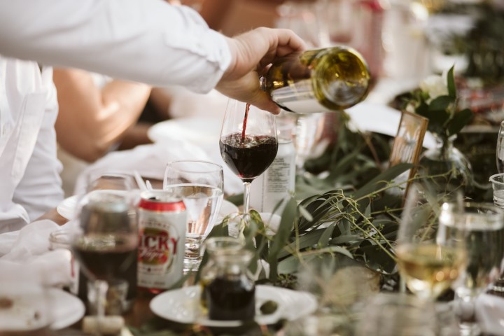 Servers pour wine for guests at forest wedding reception by Truffles Catering Vancouver Island