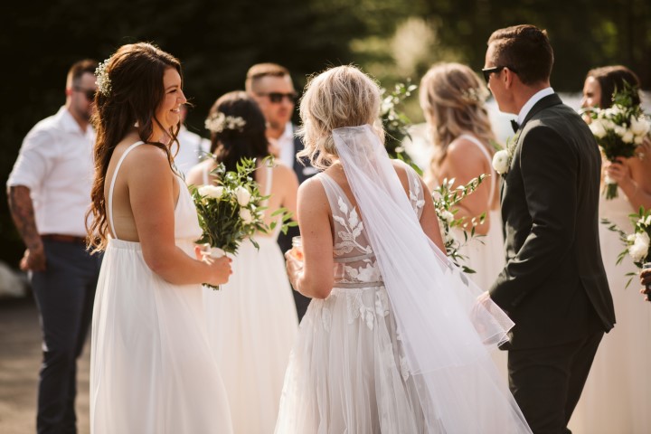 Newlyweds and wedding party during cocktail hour at forest reception