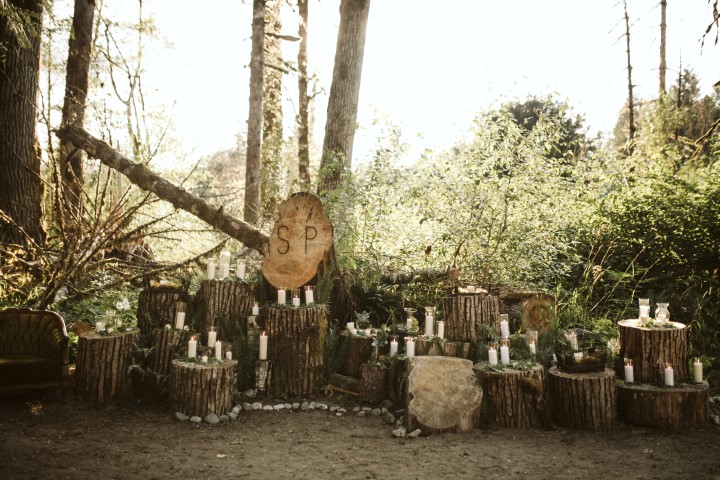 Logs with candles on top at a forest wedding by Erin Wallis Photography