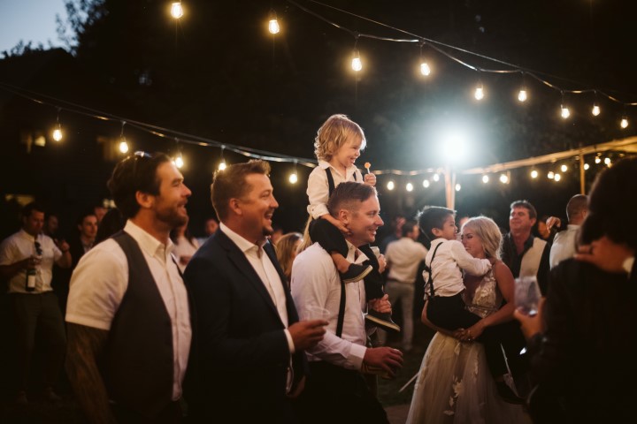 Wedding Guests watch as newlyweds have their first dance under cafe lights