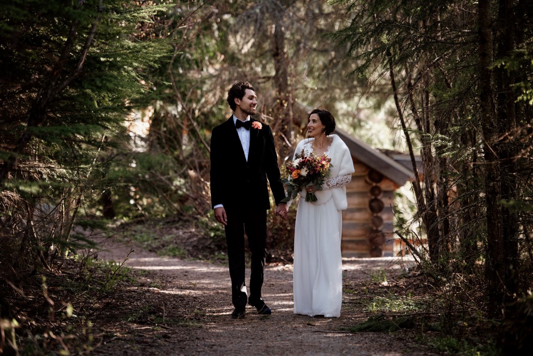 Newlyweds meander down forest path near Stone Circle Whistle by West Coast Weddings Magazine