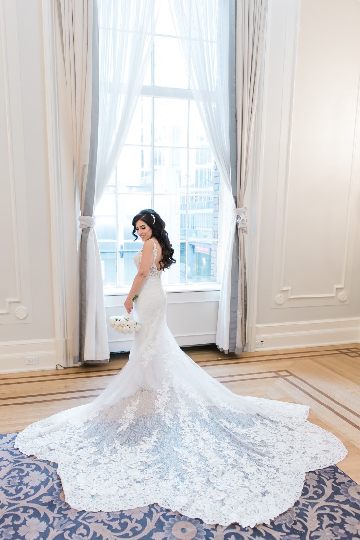 Bride with lace train spread around Bisou Bridal Martina Liana Design