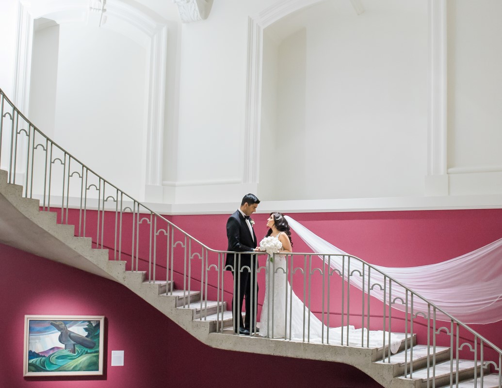 Wedding Couple stand on the stairs of Vancouver Art Gallery by Lestelle Photography