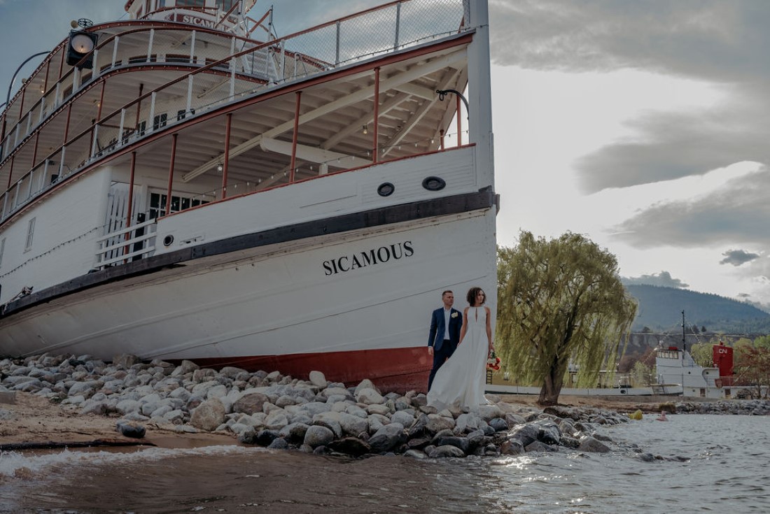 Bride and Groom kiss in front of Sicamous steamship