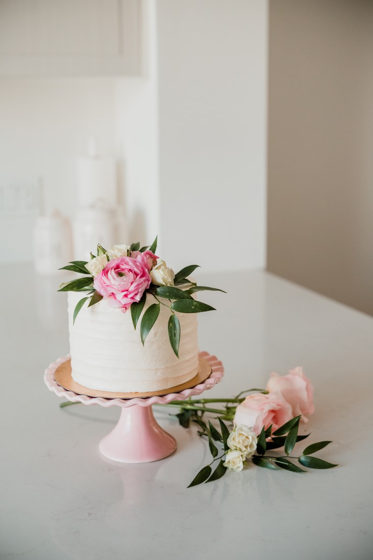 Cake n Sweets Bridal Shower vanilla iced cake on blush pink cake plate with roses and greenery