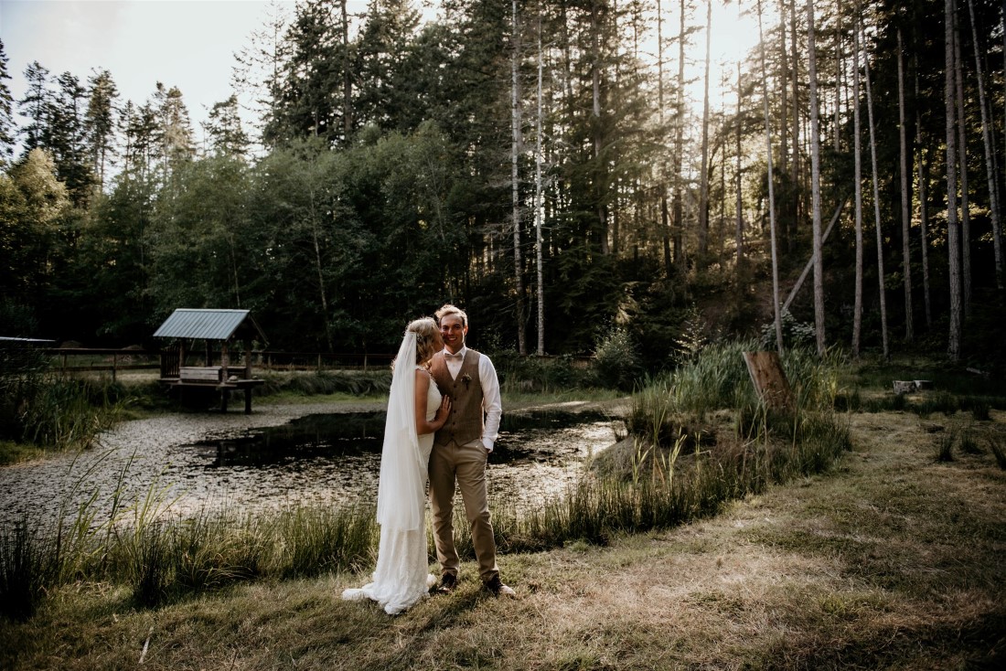 Newlyweds stand in the setting sun in Vancouver Island forest