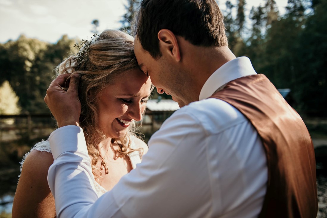 Groom holds bride during sunset on Vancouver Island