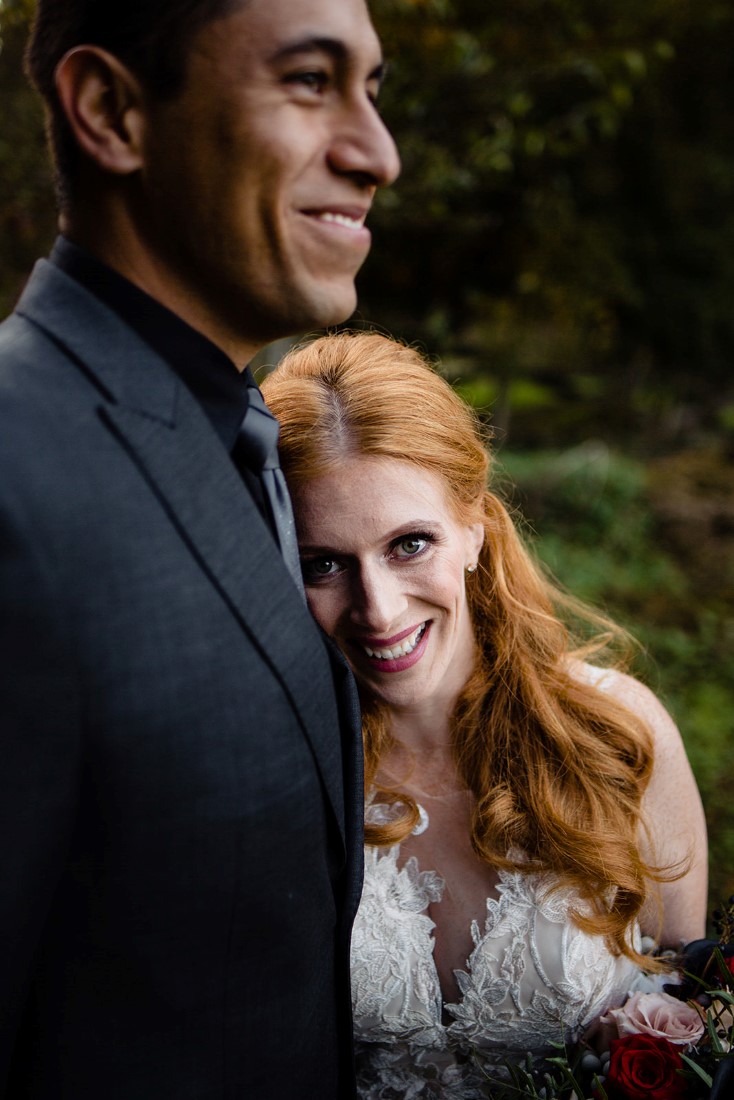 Red Headed Bride smiles while leaning on her groom by Mimsical Photography