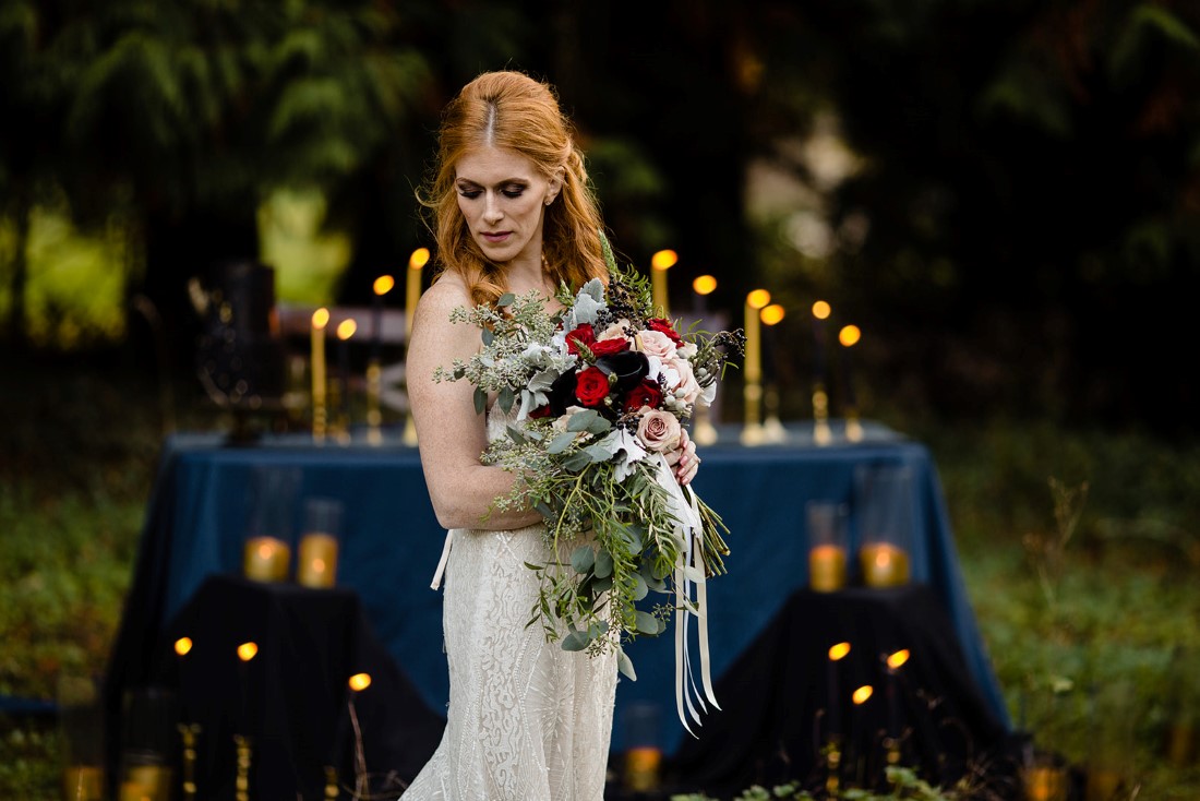 Fall Hues Bride in front of table full of candlesticks by Three Cheers Events Vancouver 